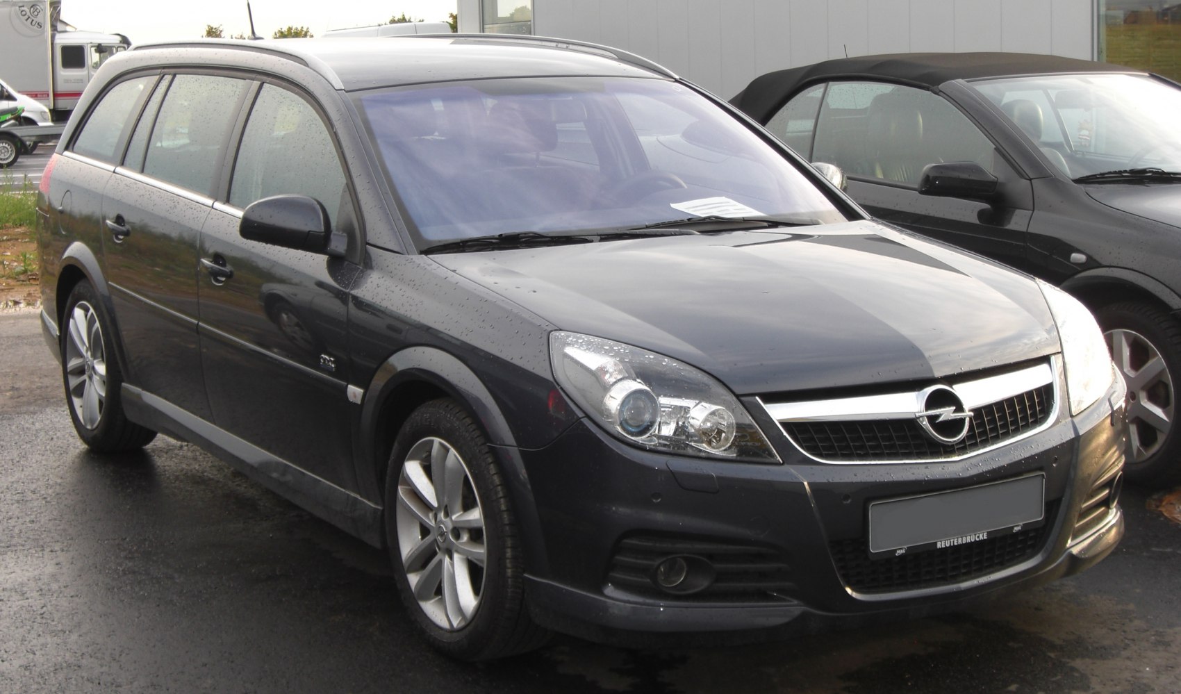 Front side view of a station wagon with dual headlights and alloy wheels