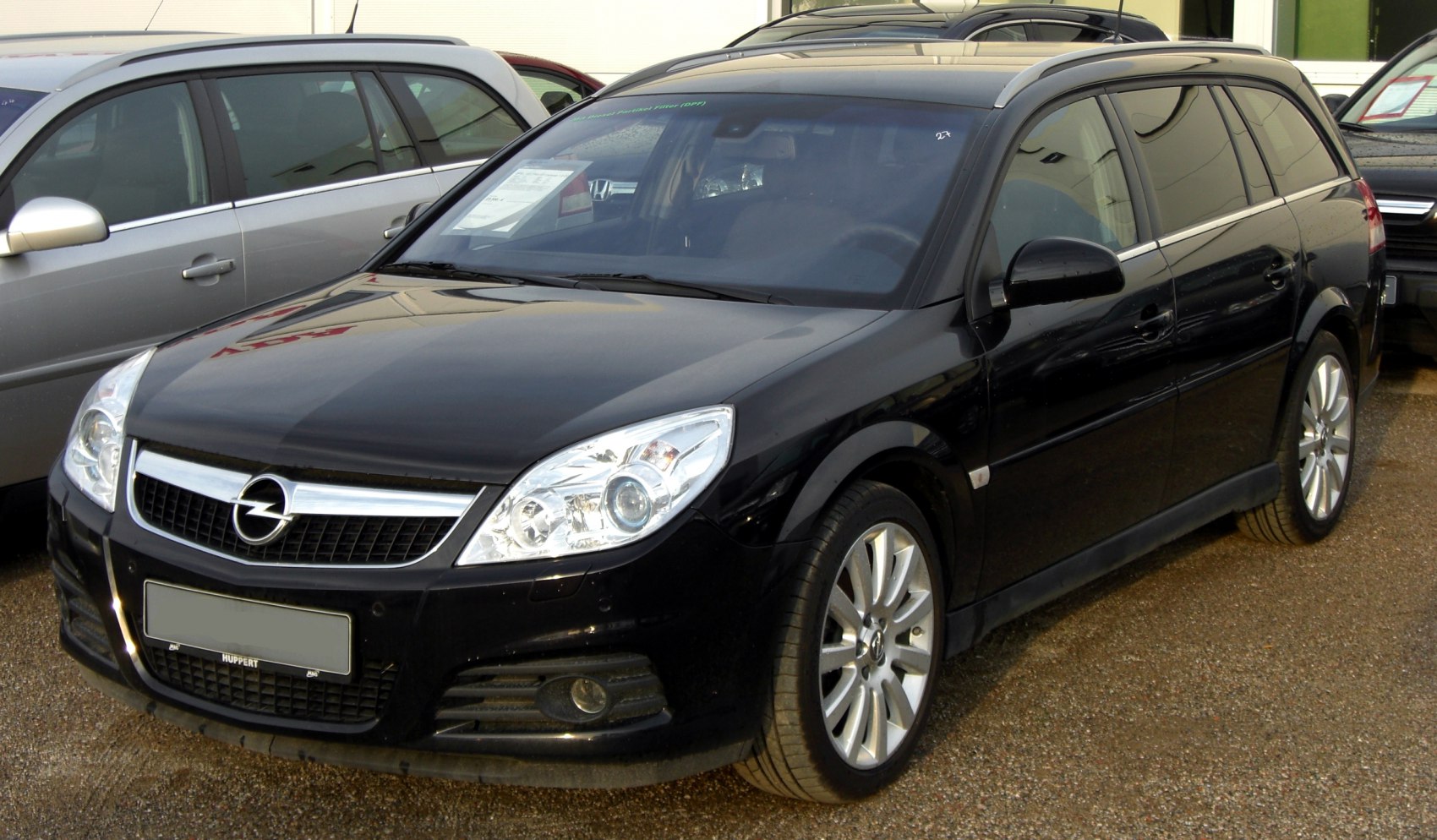 Front and side view of a sleek black estate car with distinctive grille and headlights