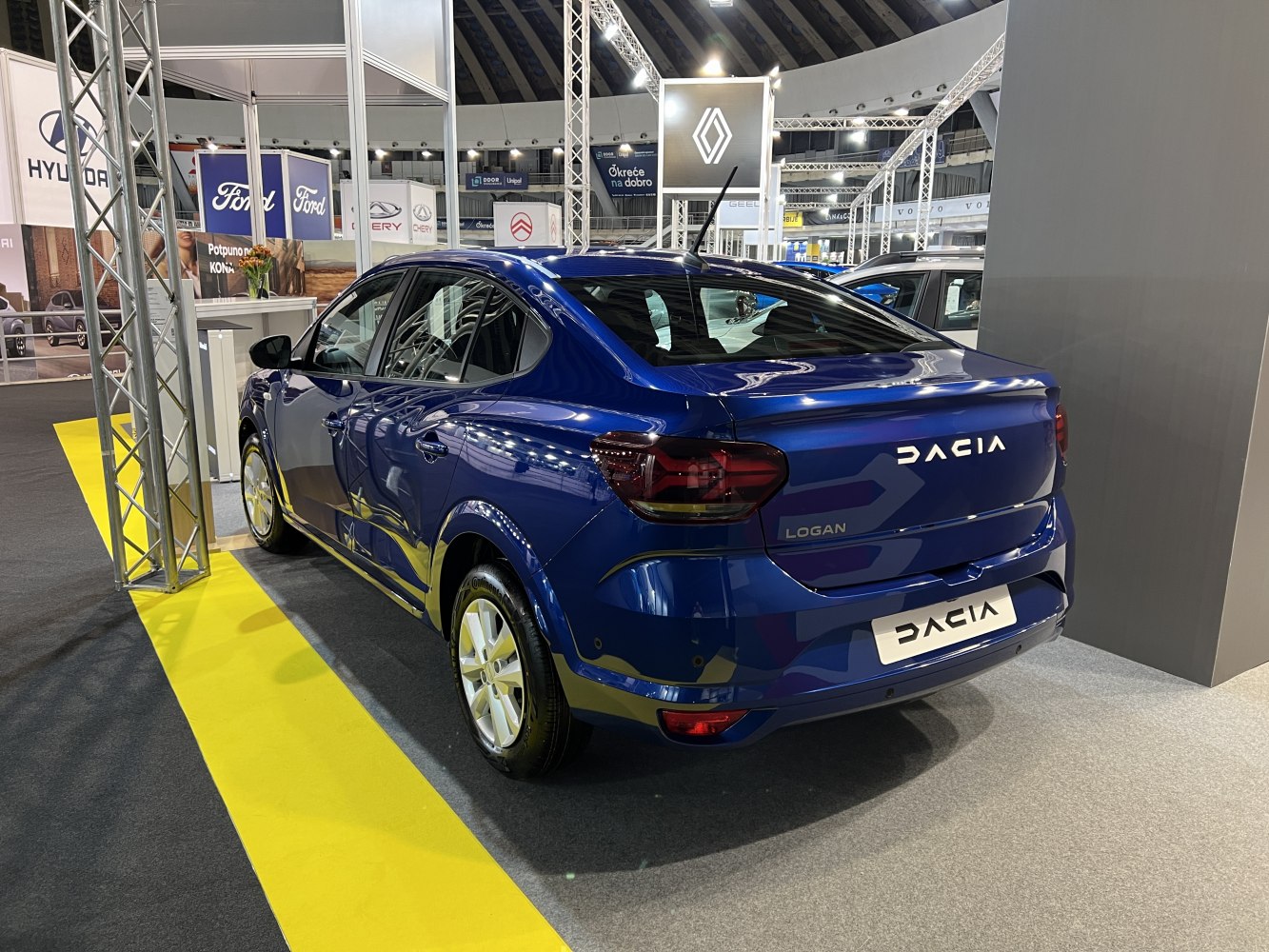 Glossy blue sedan rear with dark tail lights and alloy wheels