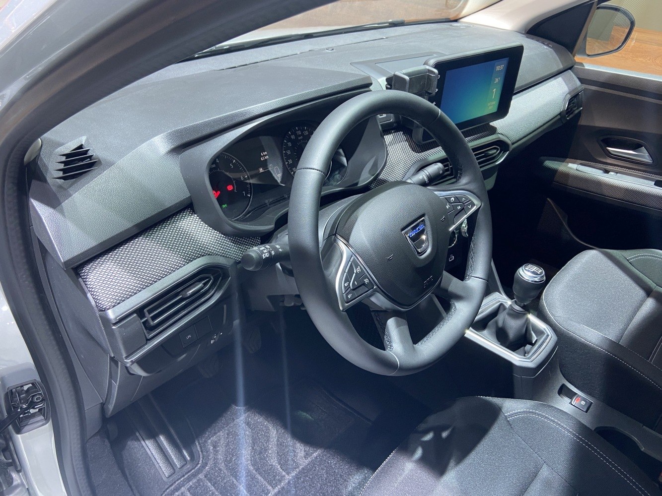 Dashboard, steering wheel with controls, and manual gear shift