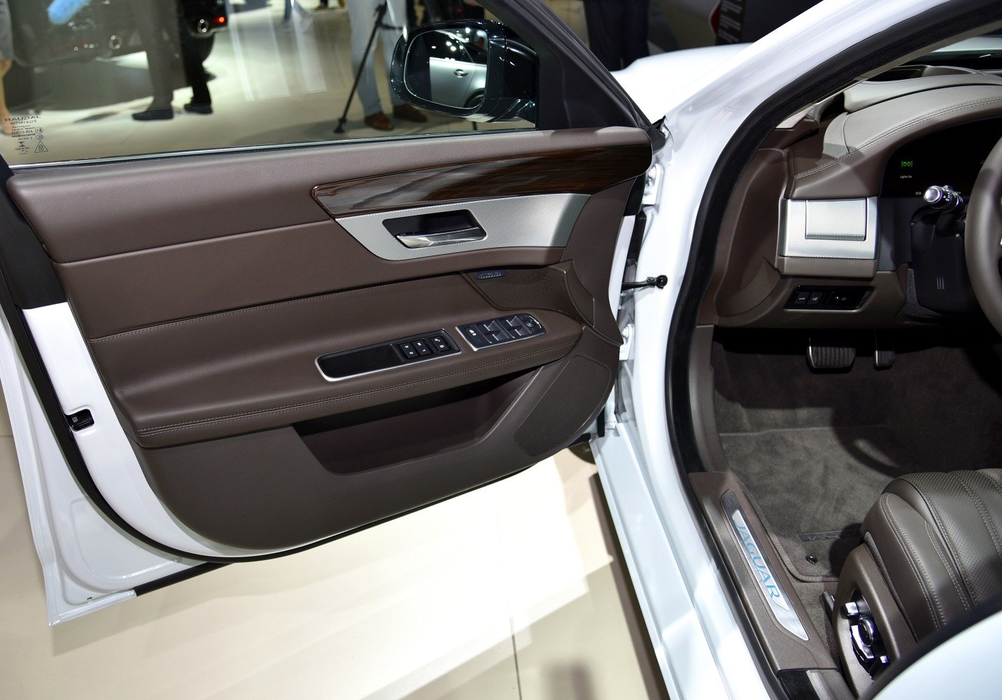 Brown leather door panel with wood trim and control buttons