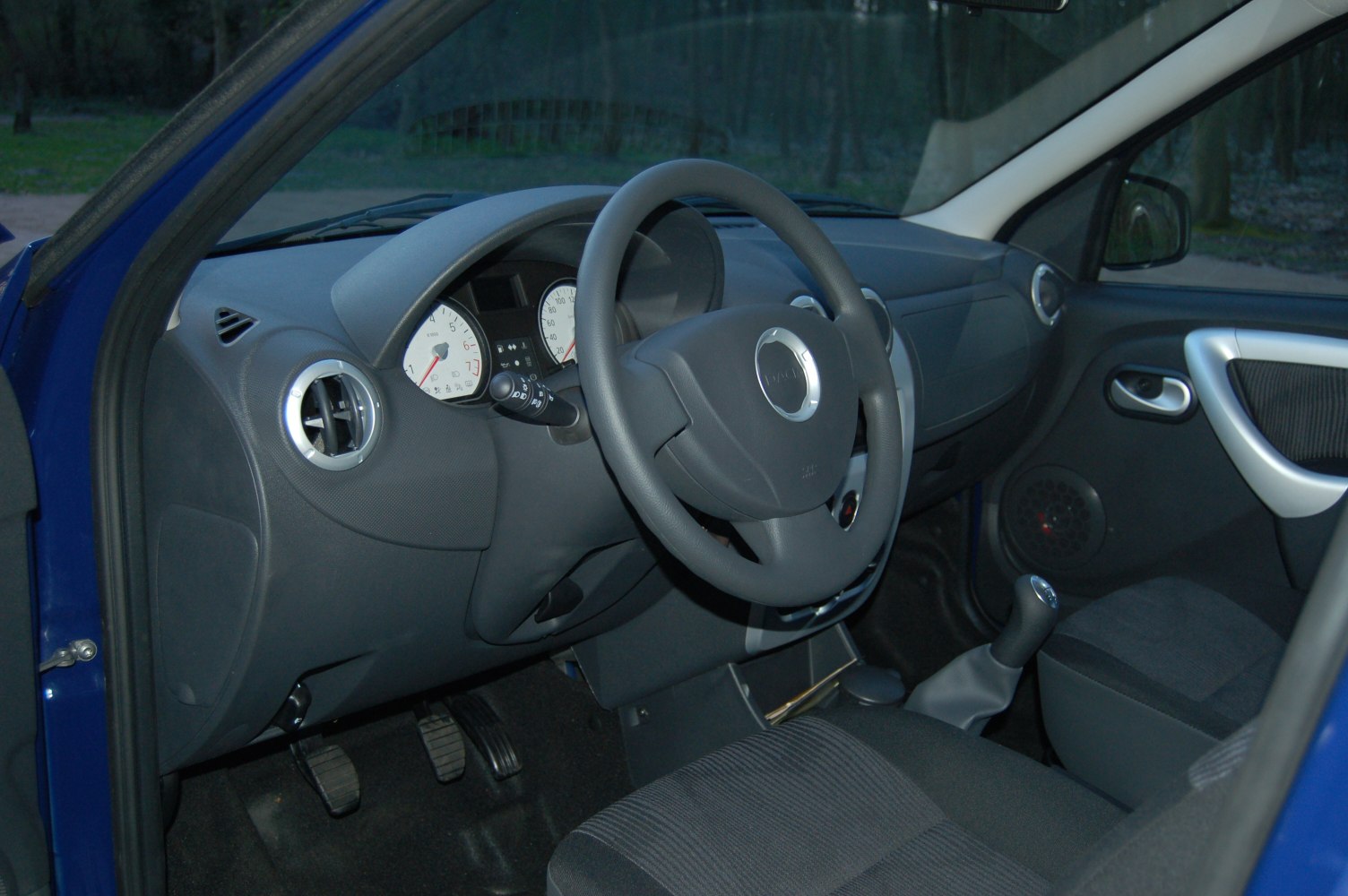 Interior view of dashboard, steering wheel, and manual gear shift