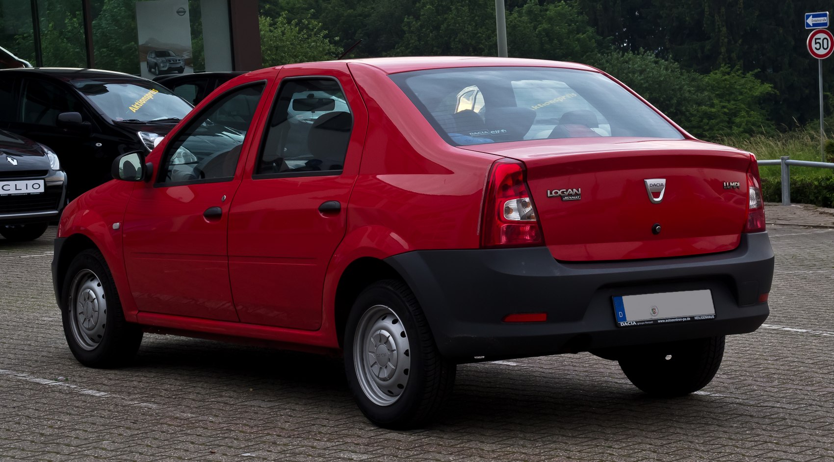 Red compact sedan rear side view with steel wheels and facelift design