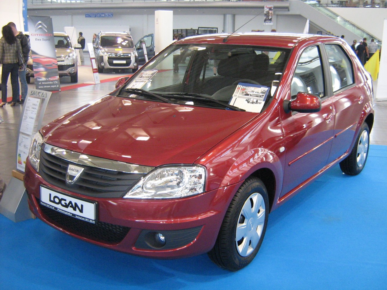Front and side view of red hatchback car indoors