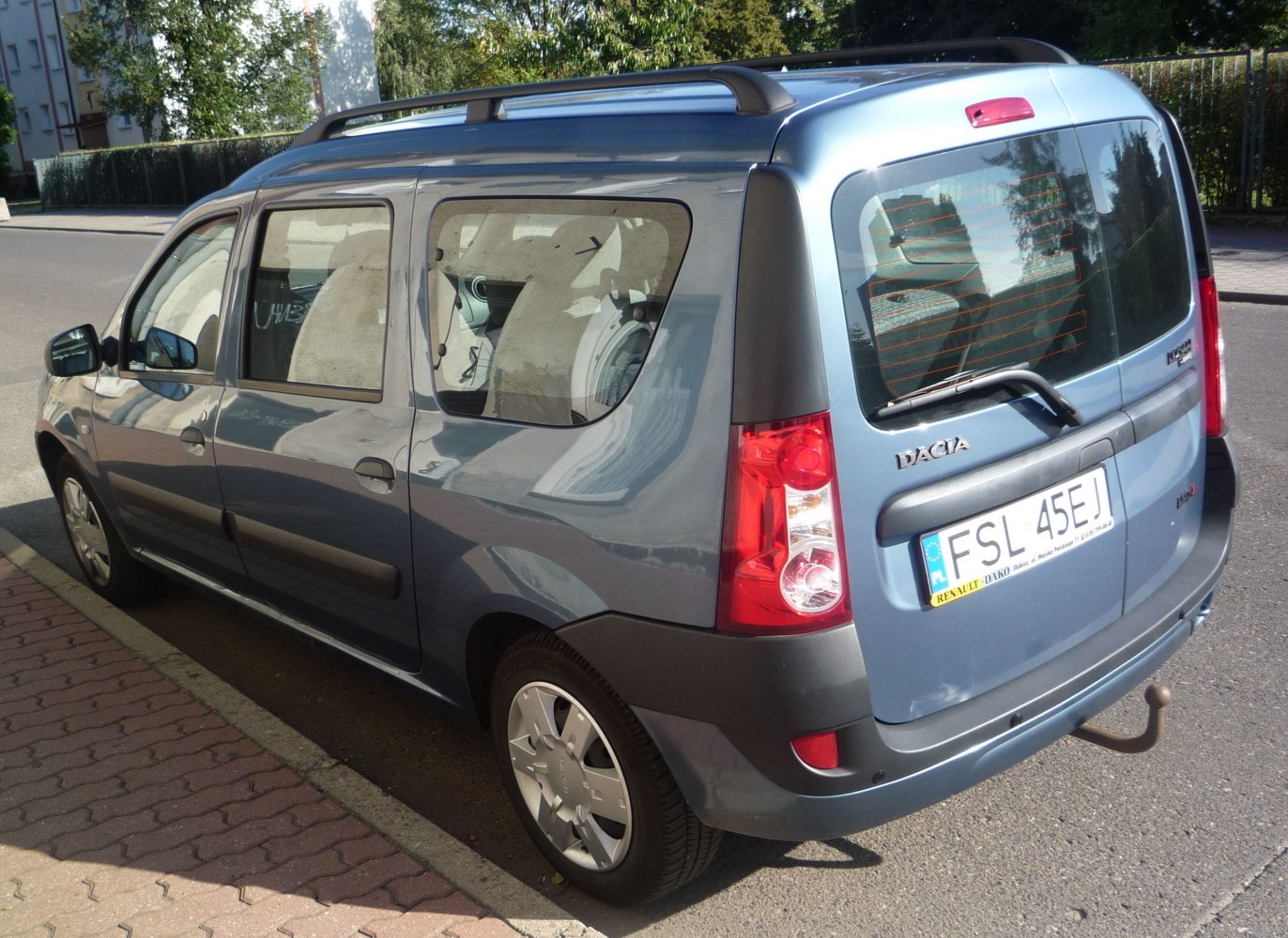 Rear-side view of practical wagon with roof rails and rear tow hitch.
