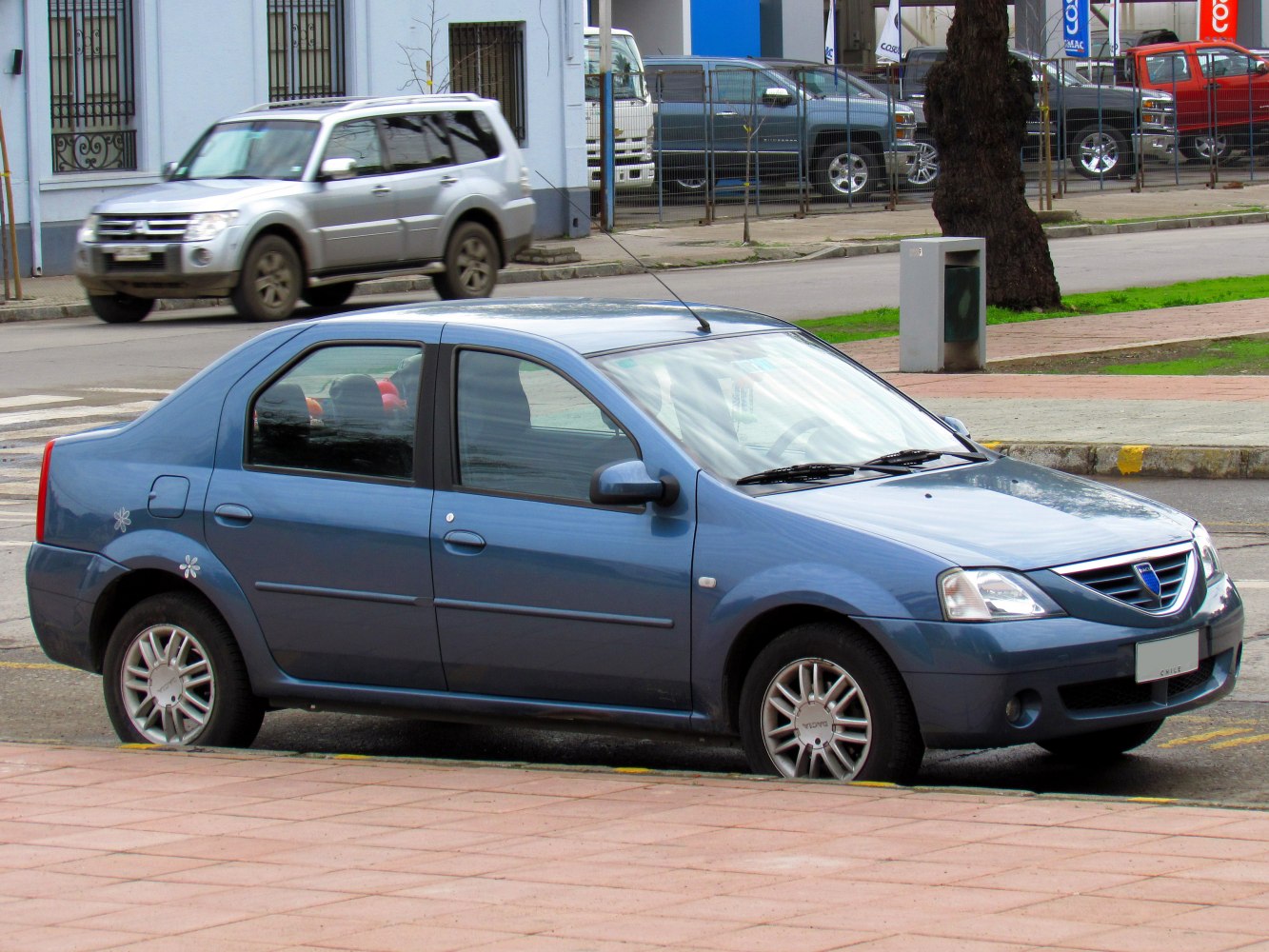 Side view of a compact sedan with alloy wheels and distinctive front grille