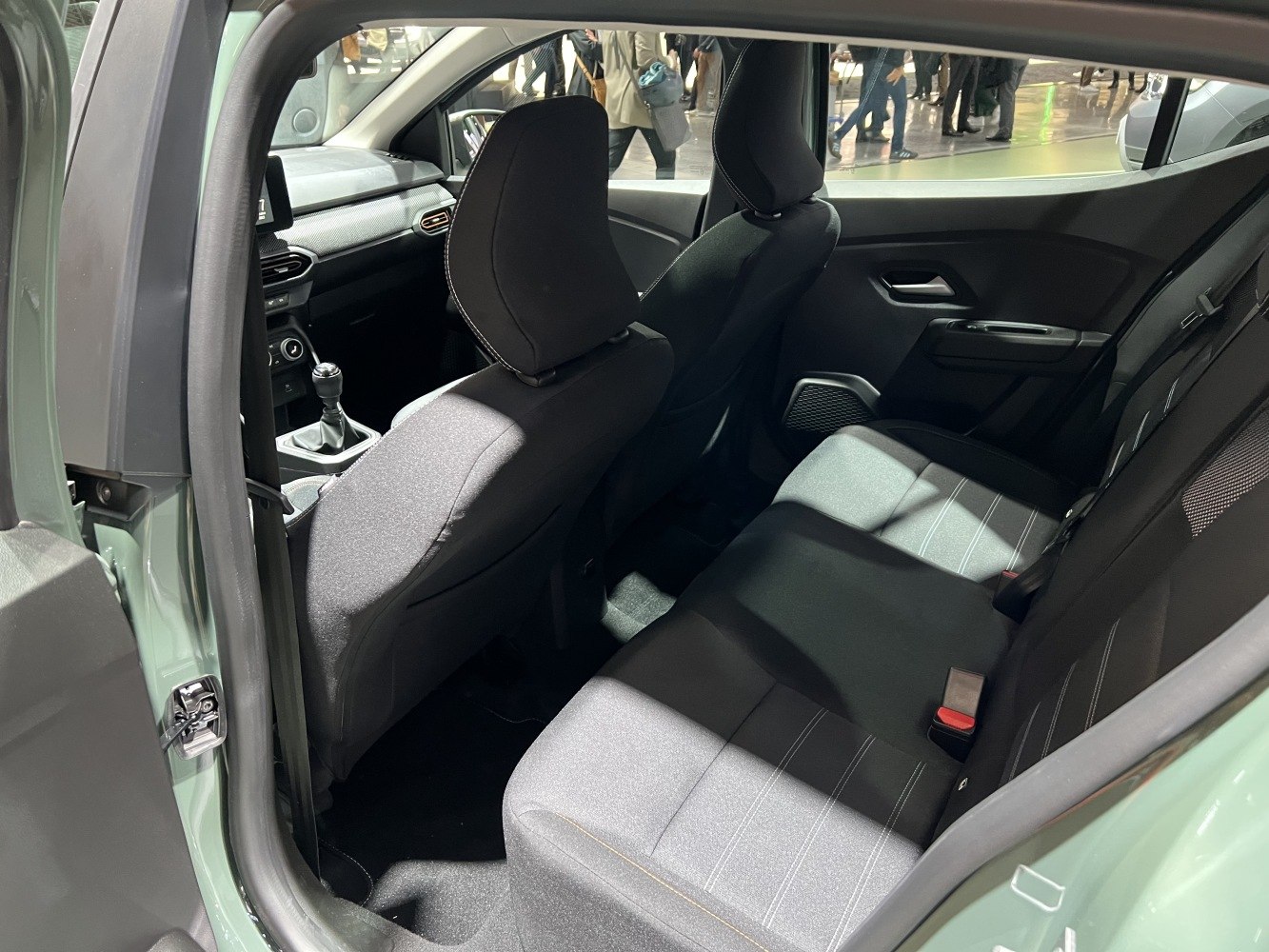 Rear interior seating and cabin layout with black upholstery and manual gearshift.