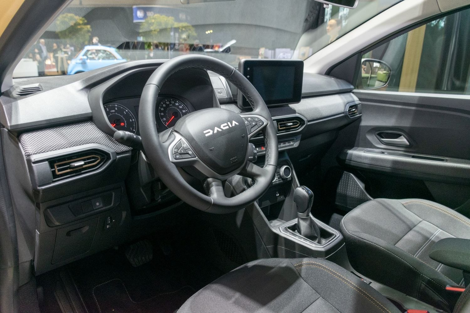 Dashboard with touchscreen, steering wheel controls, and manual gear shift