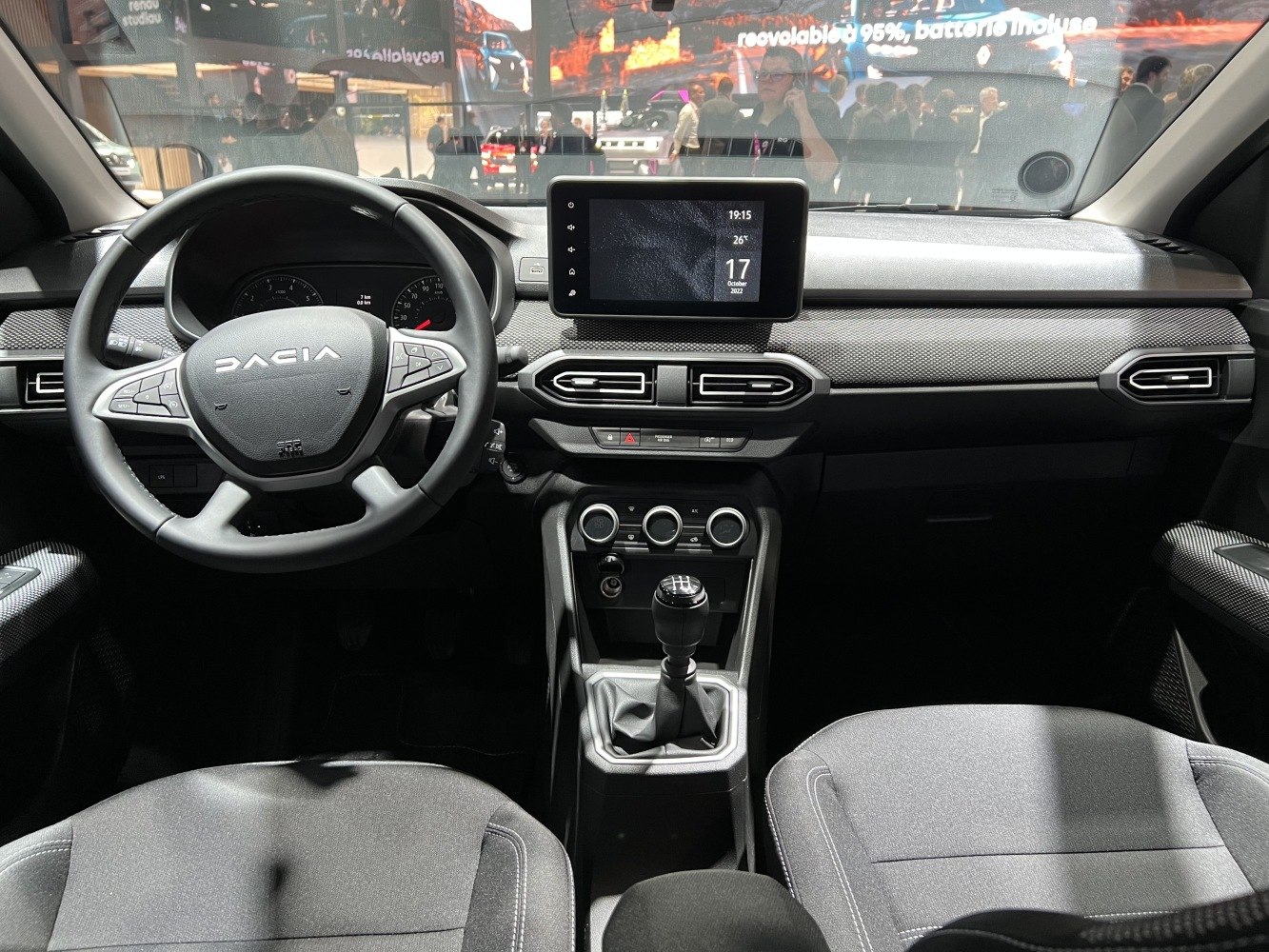 Dashboard with touchscreen display, steering wheel, and manual gear shift