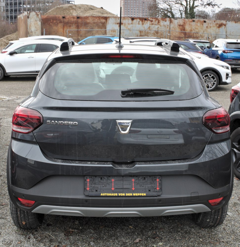 Rear view with taillights, Dacia badge, roof rails, and license plate holder