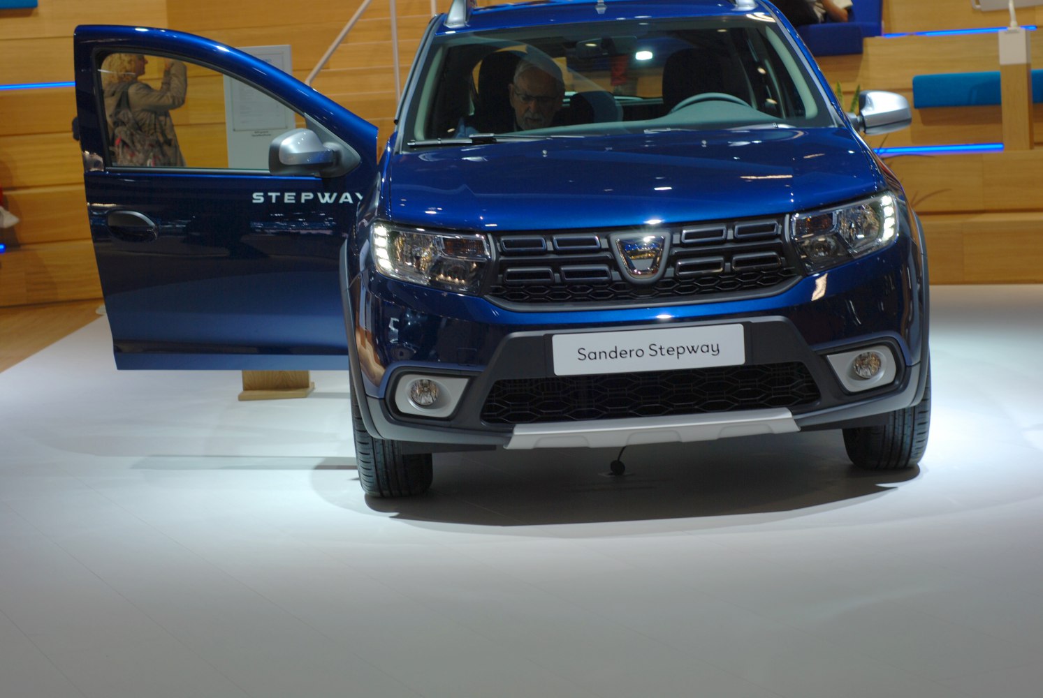 Front view with grille, headlights, and open driver door
