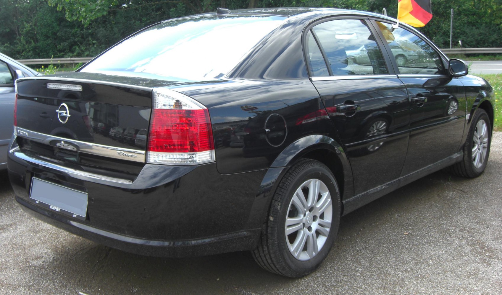 Black sedan rear side with distinctive taillights and alloy wheels
