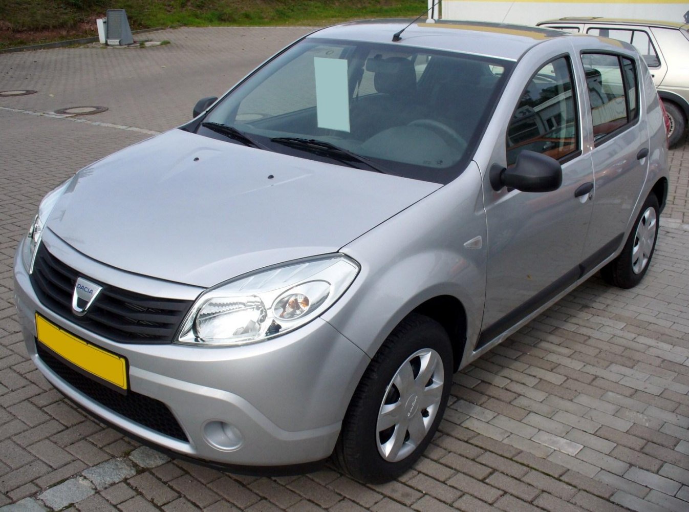 Silver compact hatchback with rounded headlights and black grille