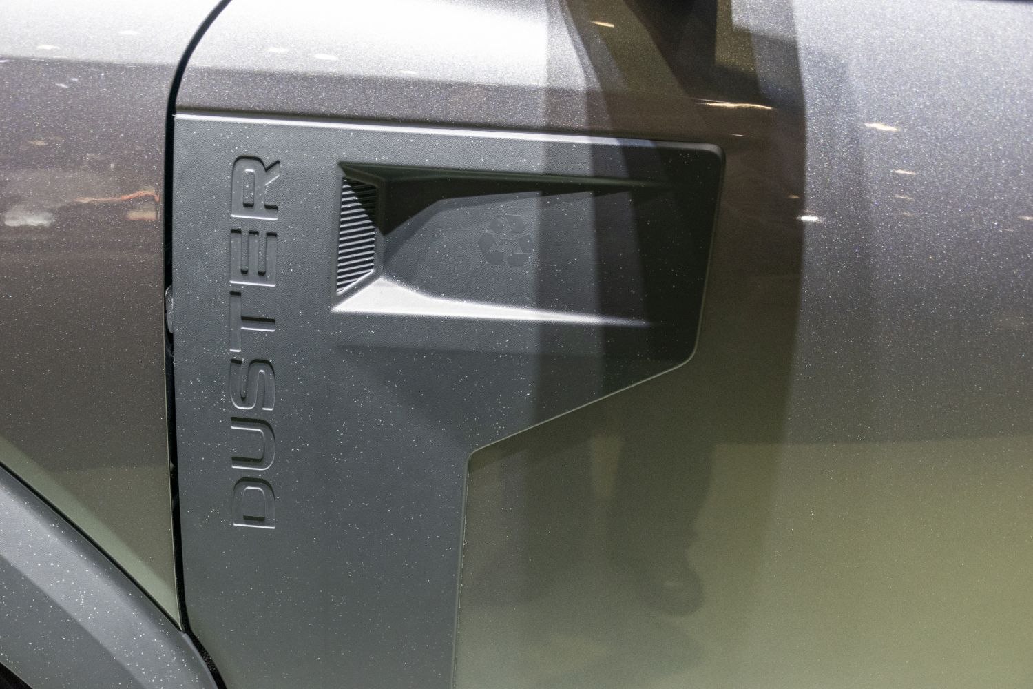 Close-up of a textured exterior side panel with embossed DUSTER lettering.