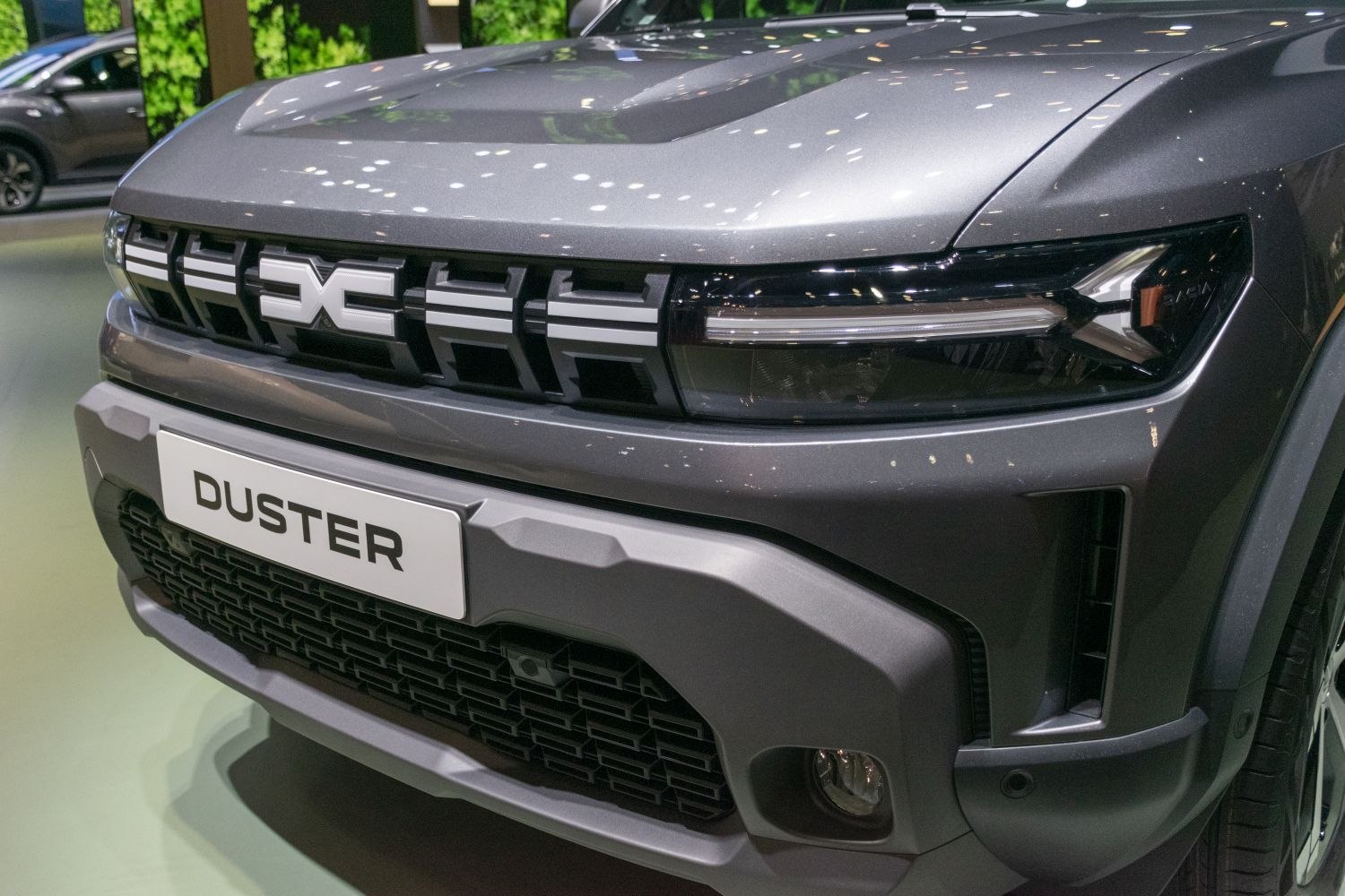 Close-up of SUV front with bold grille, distinctive badge, and sharp headlights