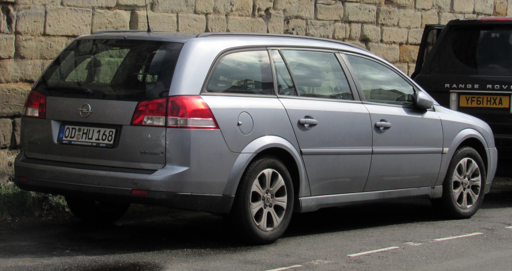 Silver station wagon rear side profile with hatchback trunk and distinctive rear lights