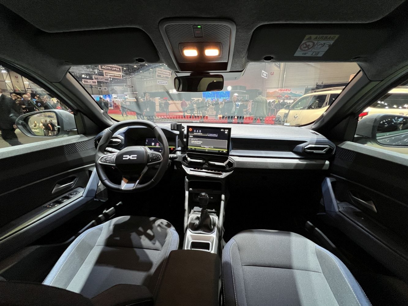 Modern SUV interior with digital displays and manual gear shifter