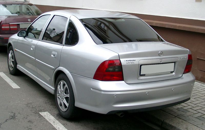 Silver sedan rear view with distinct tail lights and trunk design.