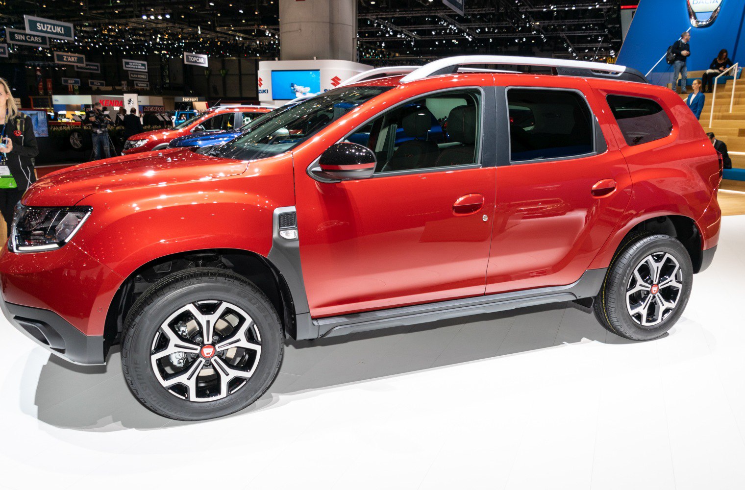 Red SUV side view with alloy wheels and roof rails