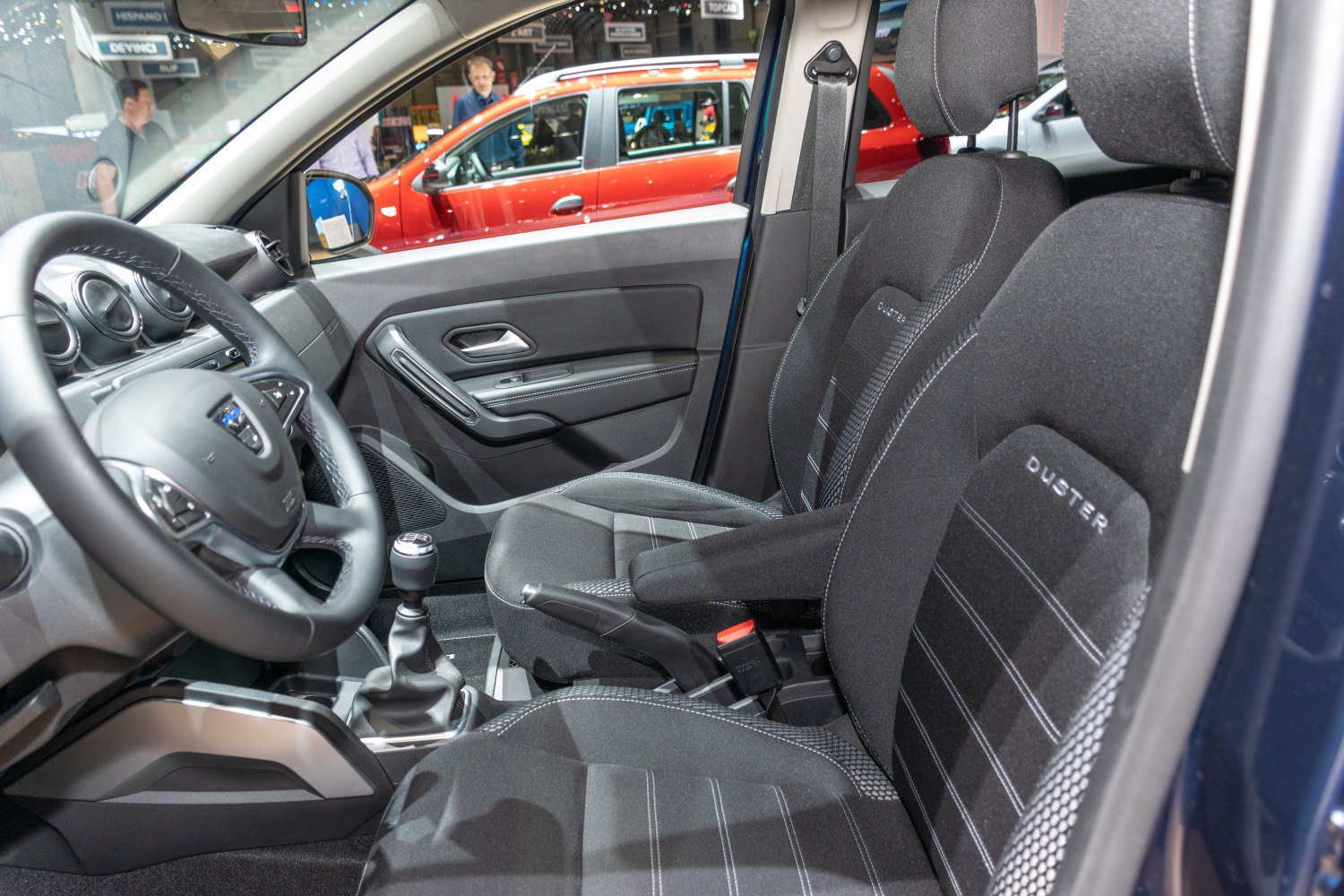 Front seats, steering wheel, gear shift, and car door panel interior details