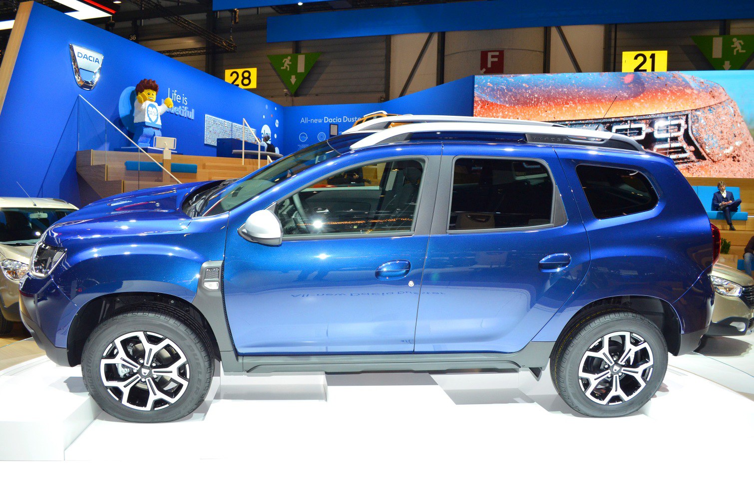 Side view of a blue SUV with alloy wheels and roof rails