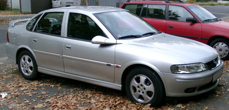 Silver sedan side view with alloy wheels and aerodynamic shape.