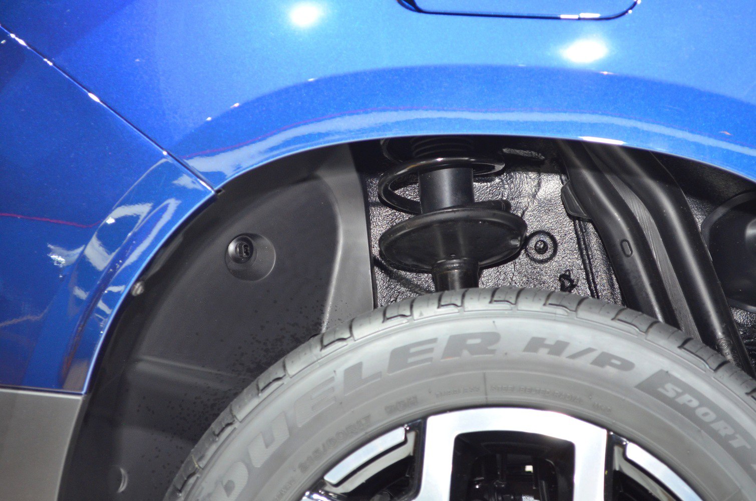 Suspension strut and tire sidewall close-up in wheel well