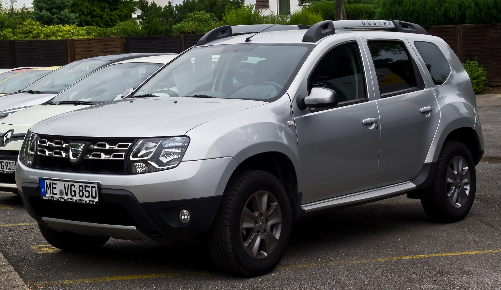 Silver off-road SUV with roof rails and alloy wheels, front-side view.