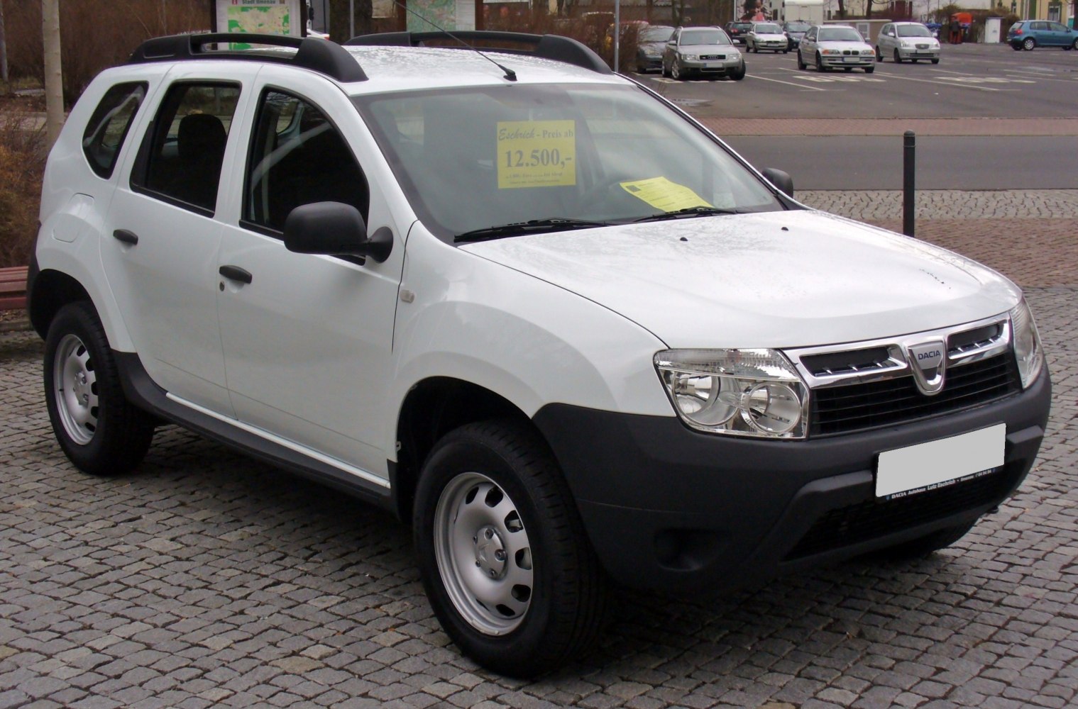 White compact SUV with black bumper and roof rails, front-side perspective.