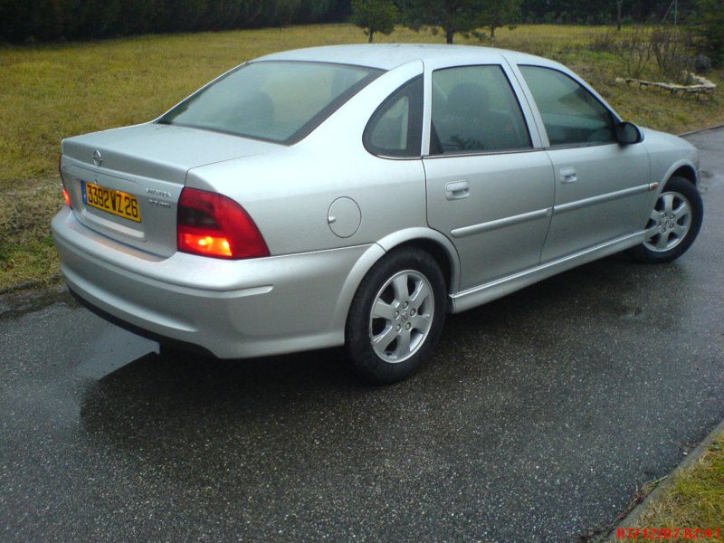 Silver four-door sedan rear side with alloy wheels and taillights.