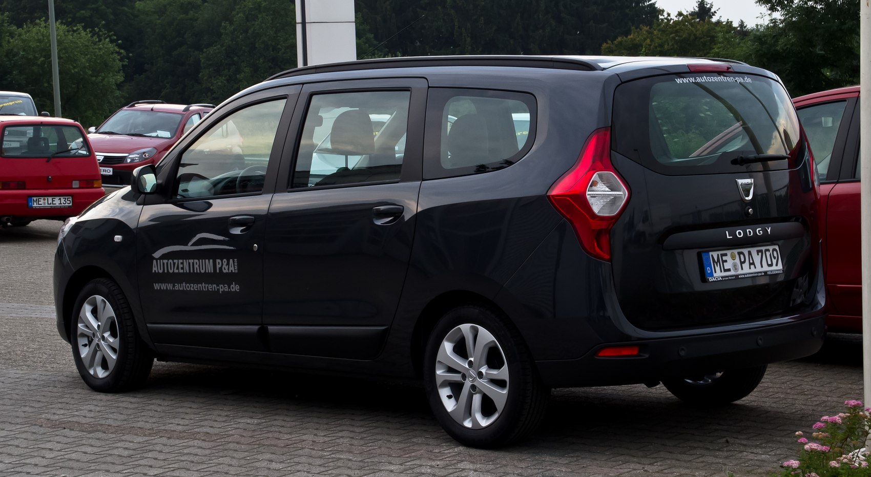 Rear-side view of a compact MPV with geometric tail lights and black paint.