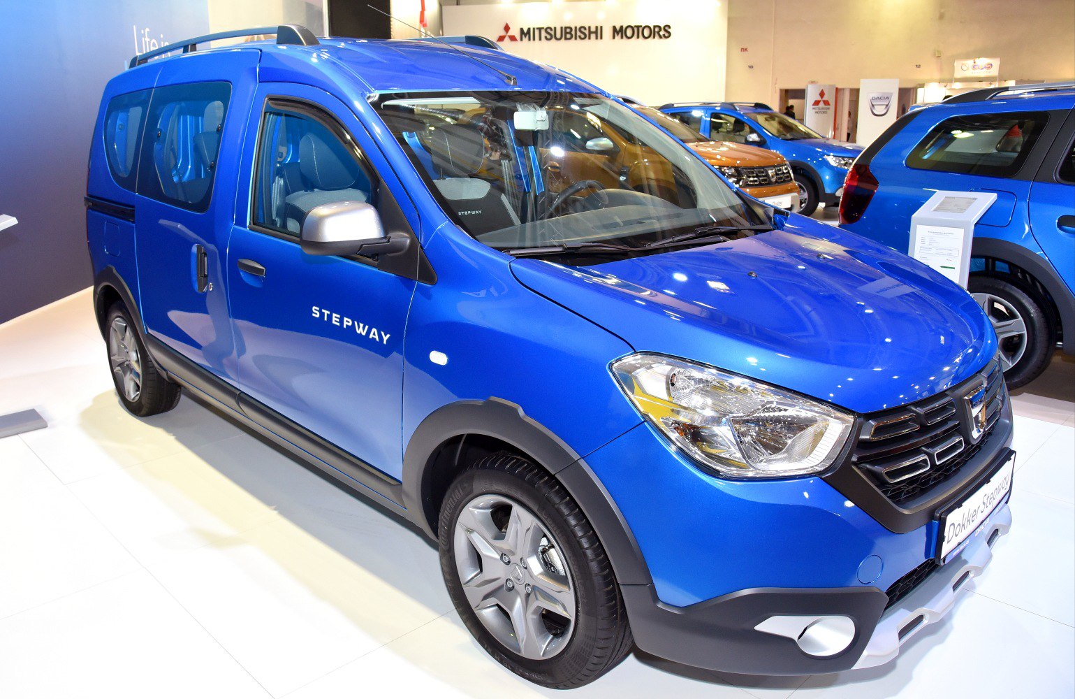 Blue vehicle with rugged trim, alloy wheels, front side view, distinctive headlights
