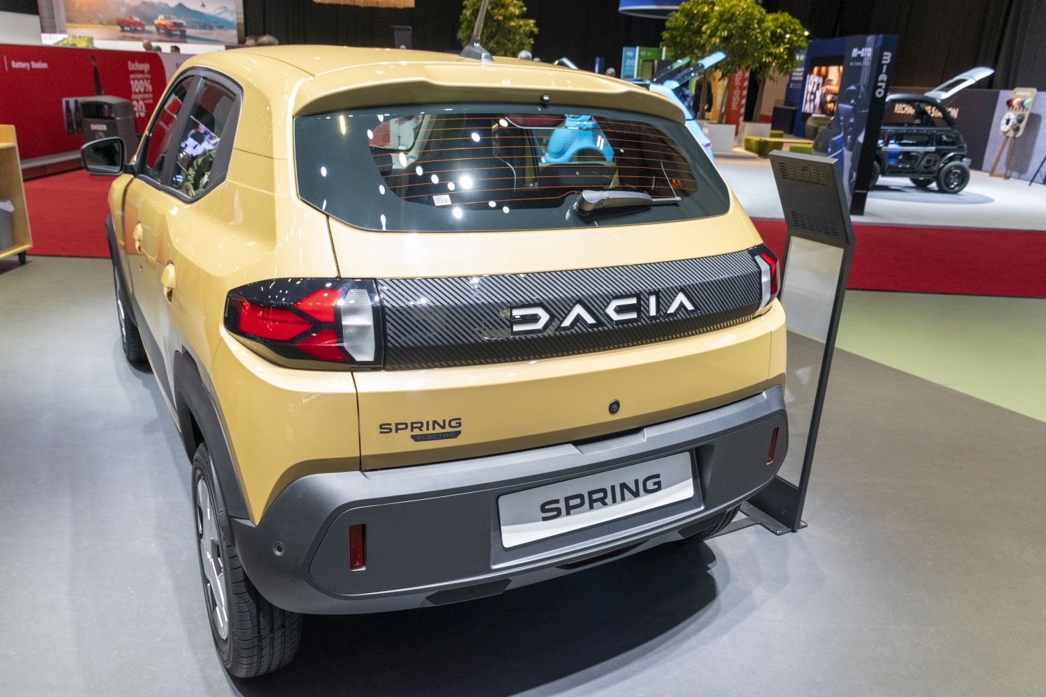 Rear view of a compact electric vehicle with carbon-style trim and distinctive taillights
