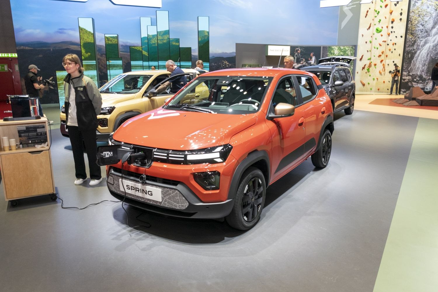 Orange electric compact SUV with facelift front and charging port