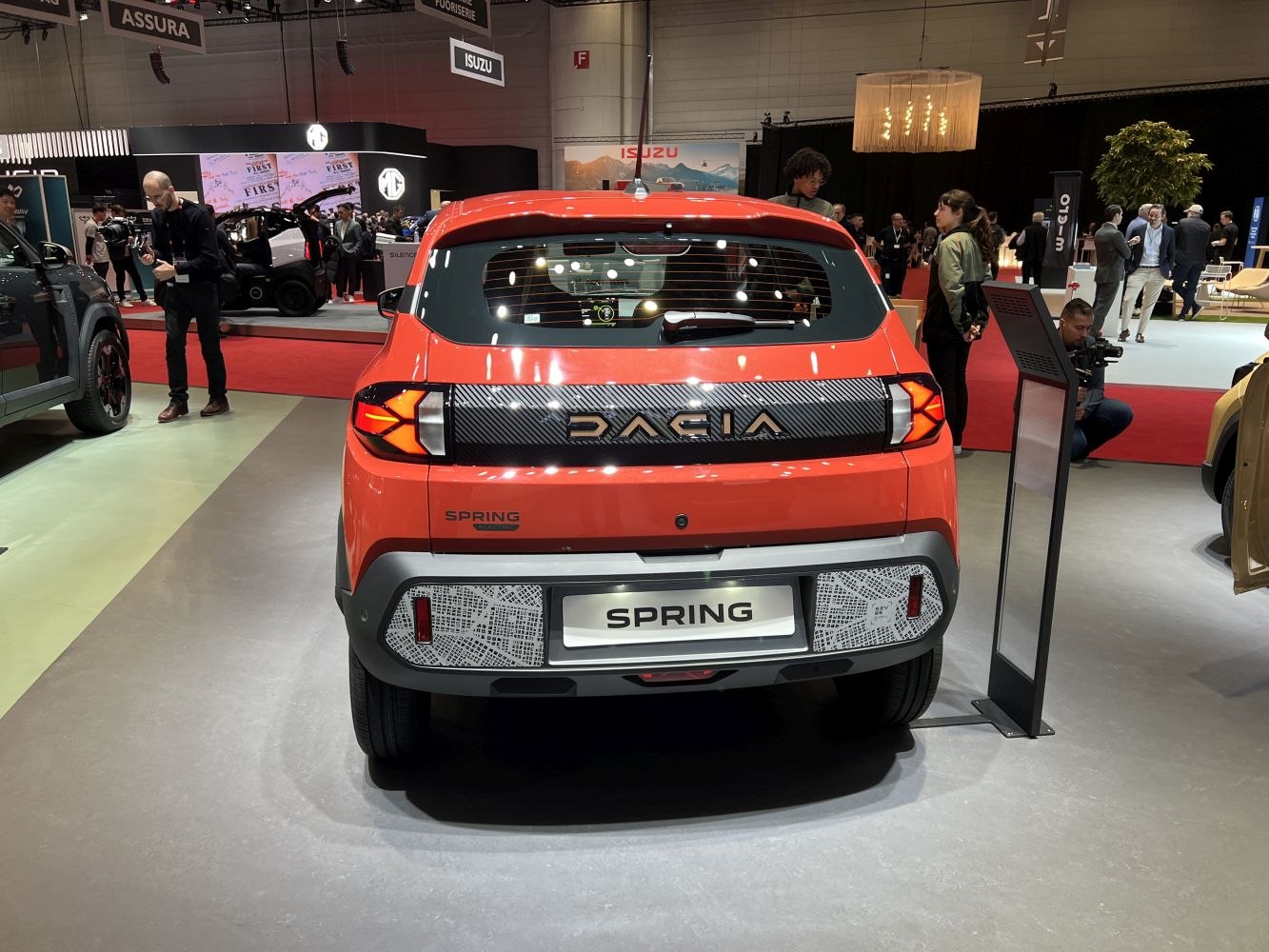 Rear view of electric vehicle with distinctive taillights and large brand lettering.