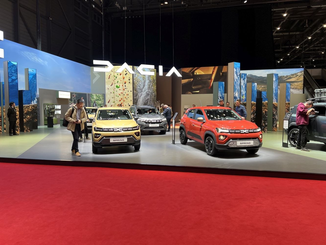 Two facelift Dacia Spring electric SUVs showcased in showroom with updated front design.