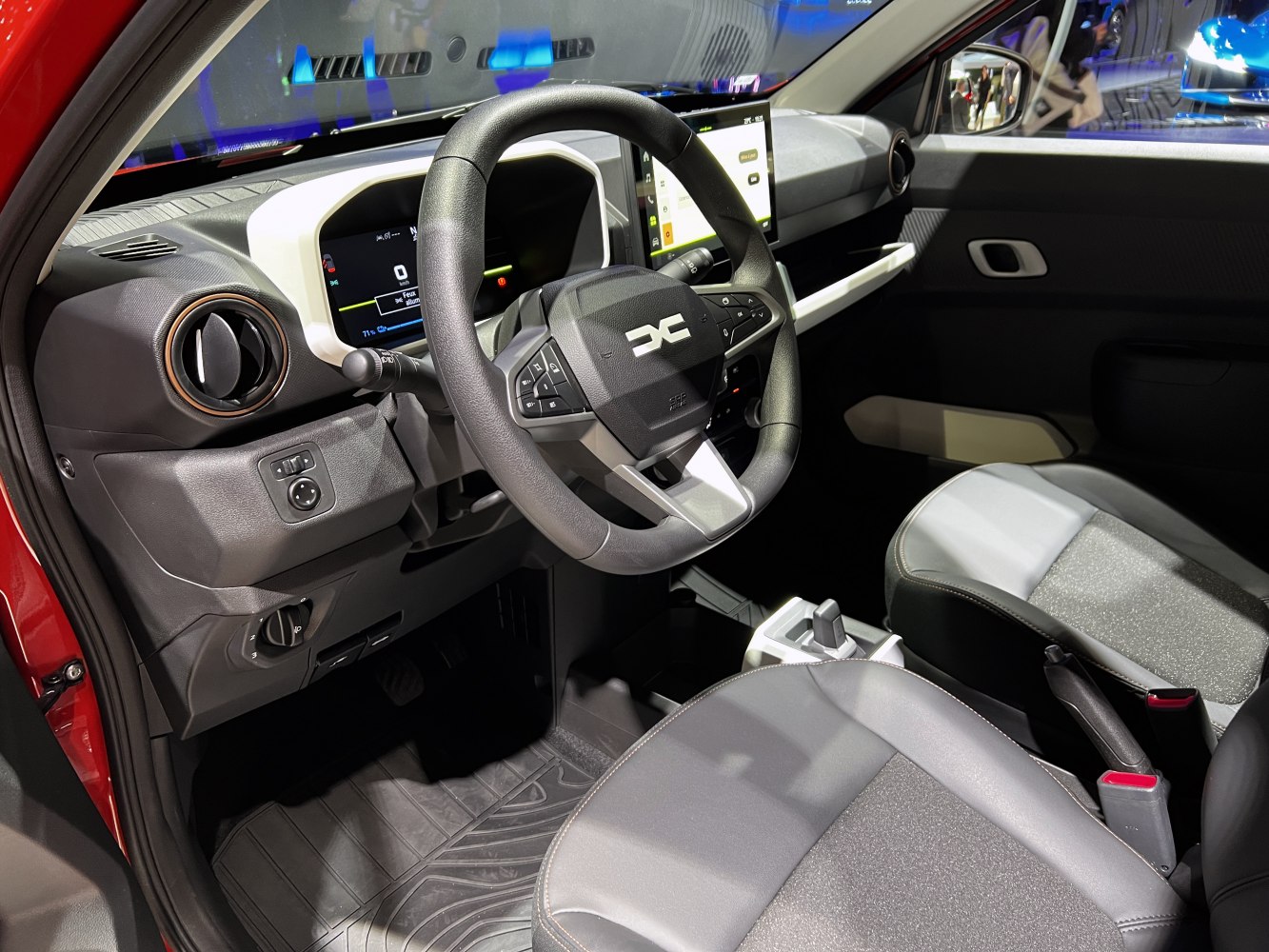 Modern digital dashboard and multifunction steering wheel with advanced controls inside compact EV.