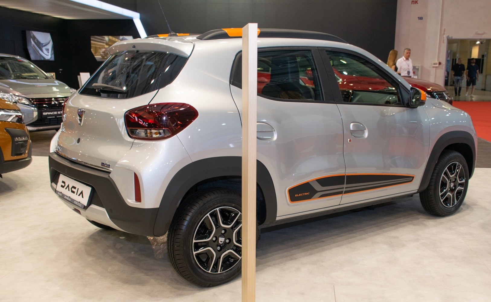 Rear and side view of a compact electric SUV with distinctive styling and orange accents.