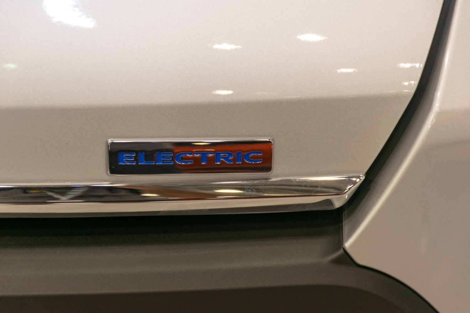 Close-up of an electric emblem badge on a vehicle door panel