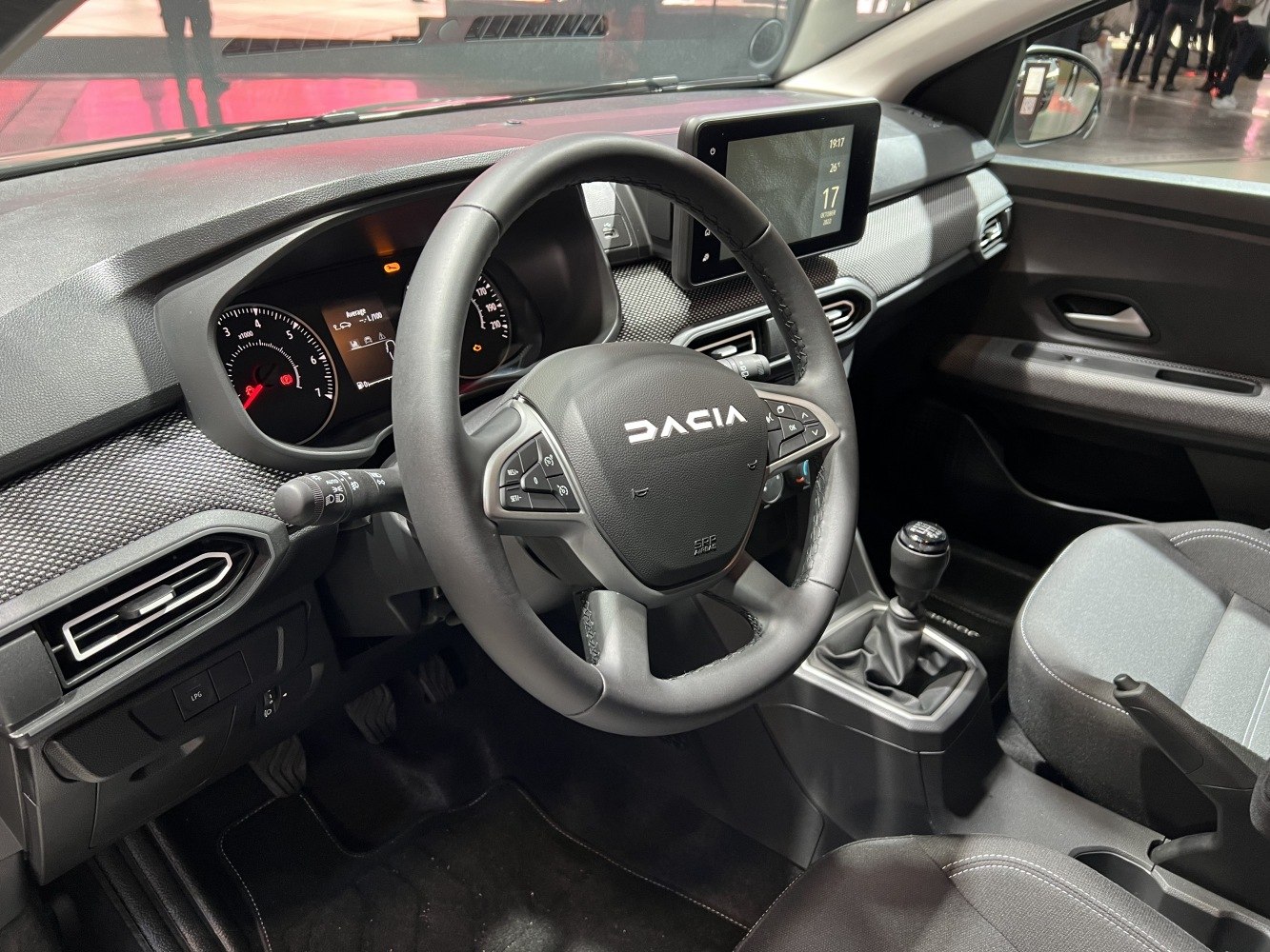 Digital instrument cluster and manual transmission gear stick in car interior