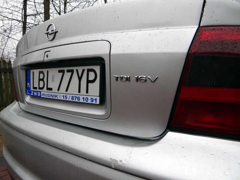 Rear badge and license plate close-up on silver car