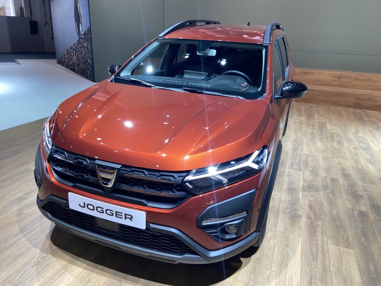 SUV front with LED headlights, roof rails, bold grille in metallic orange