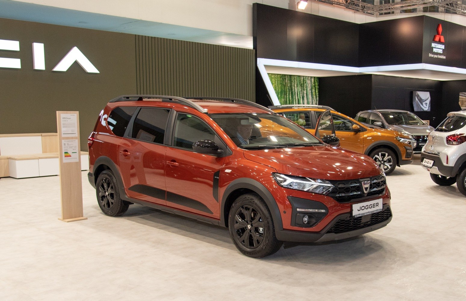 Front side of metallic orange SUV with black alloy wheels and roof rails