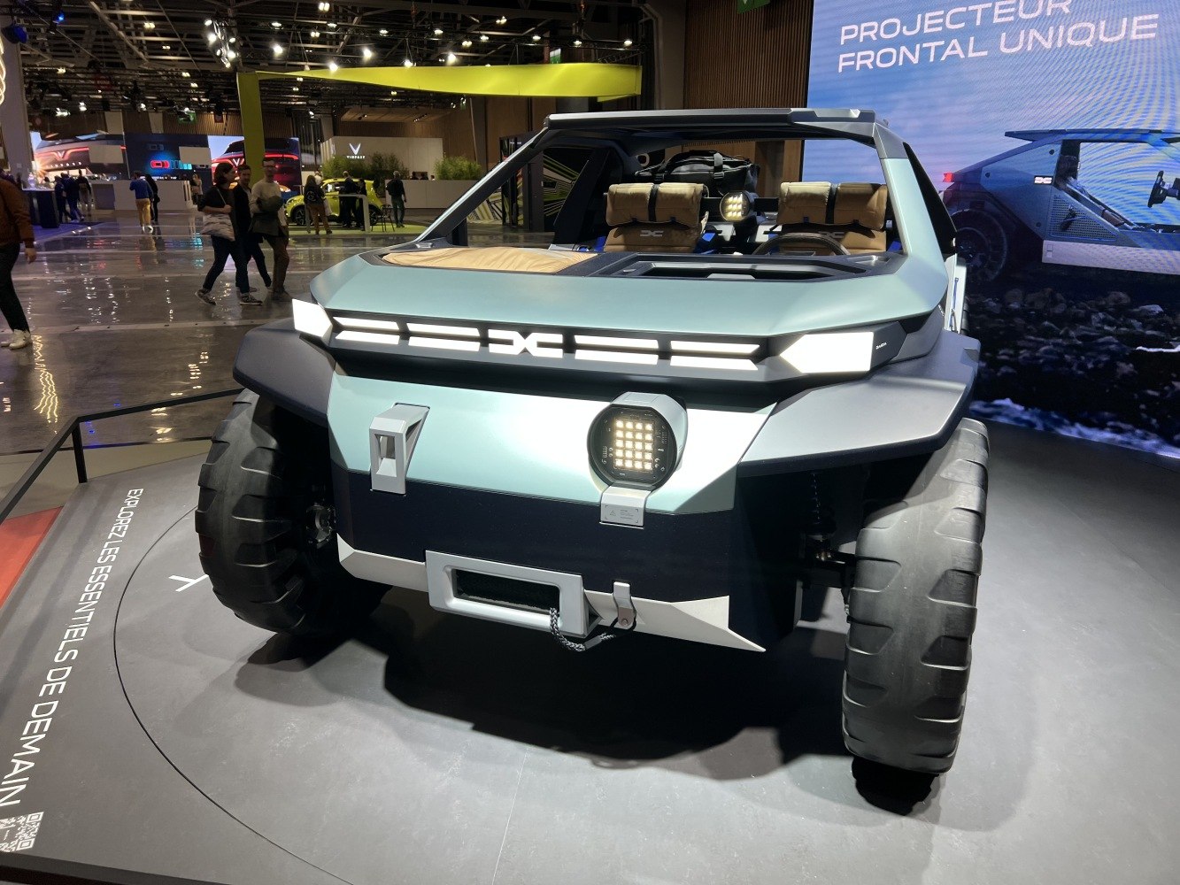 Futuristic off-road SUV front with rugged tires and unique LED lighting.