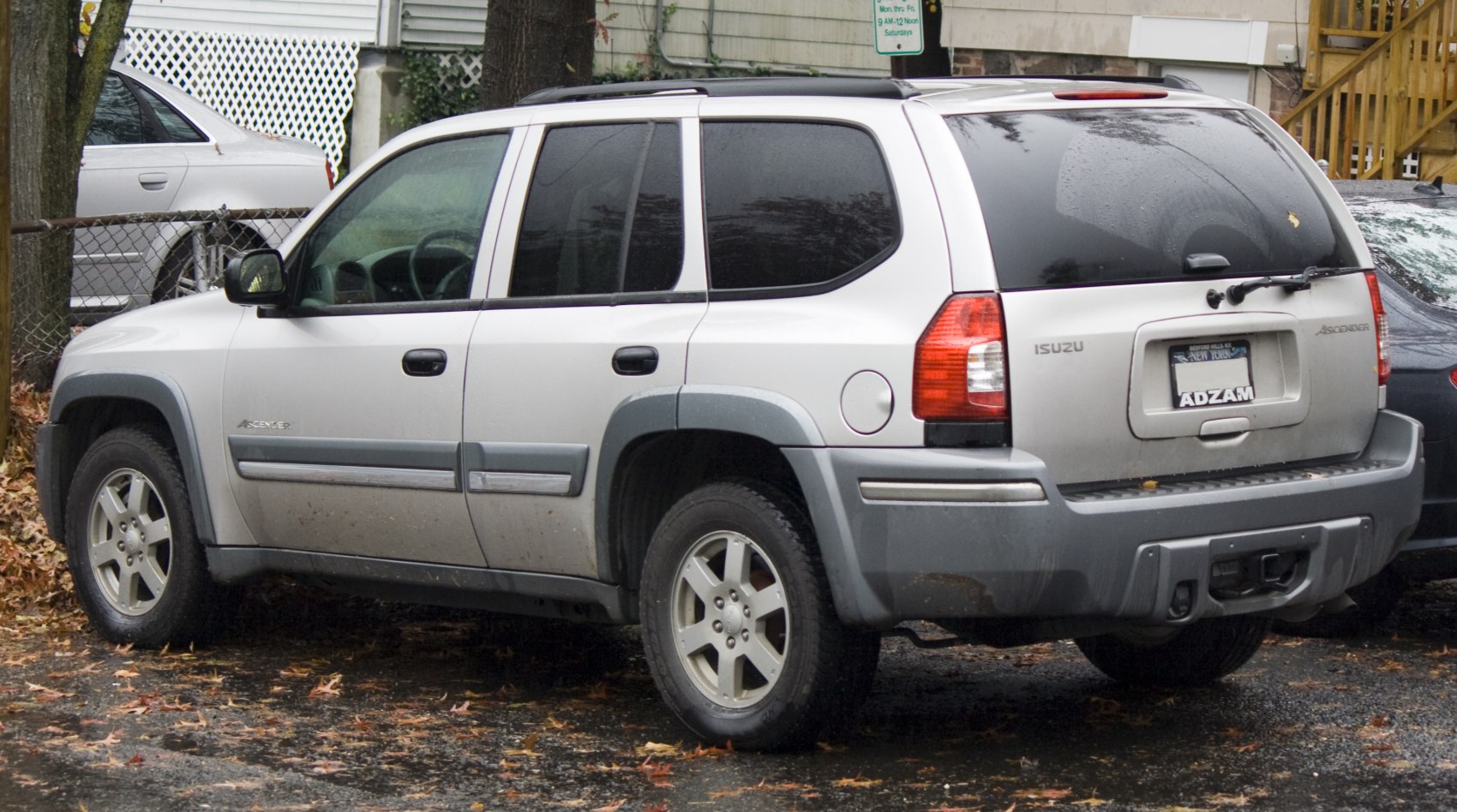 Silver mid-2000s SUV side and rear view with roof rails and tinted windows