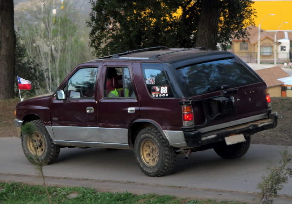 Rear side of 1990 SUV with off-road tires and roof rails