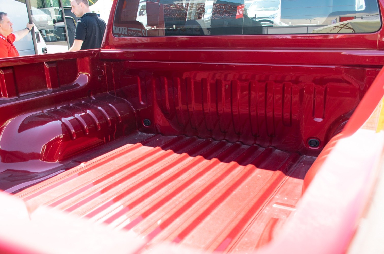 Close-up of red pickup truck cargo bed with ridges and wheel arches