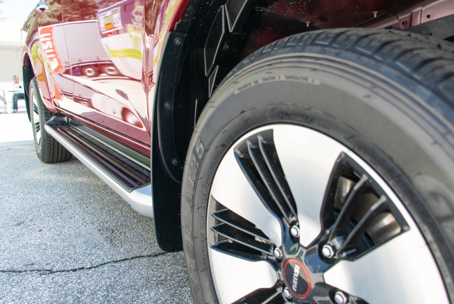 Close-up of alloy wheel rim and side step on a pickup.