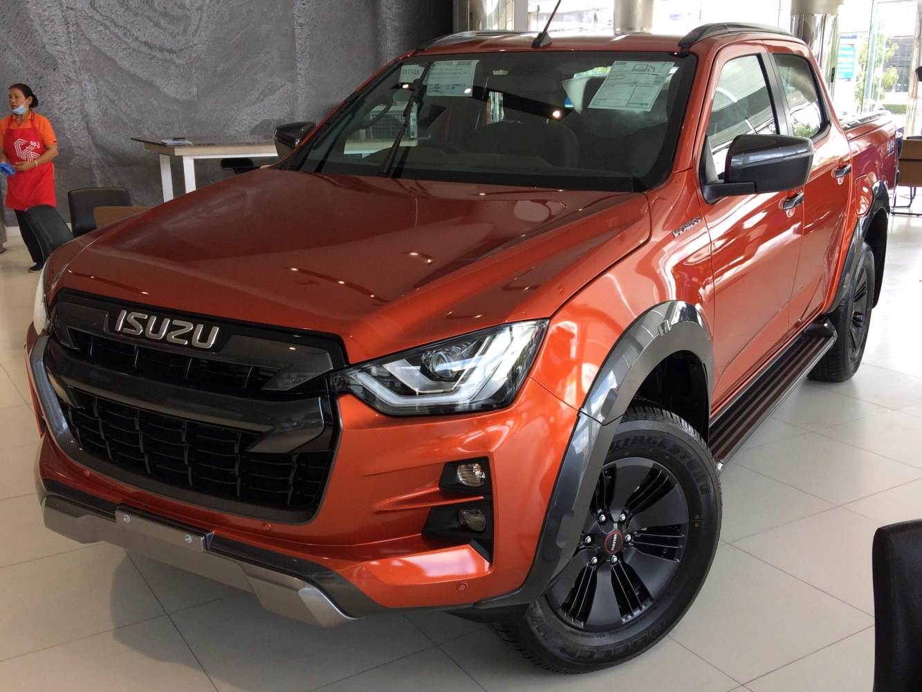 Front view of orange pickup with LED headlights and black wheels