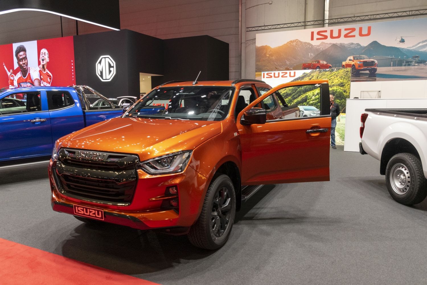 Front view of orange pickup with open driver door and black grille.